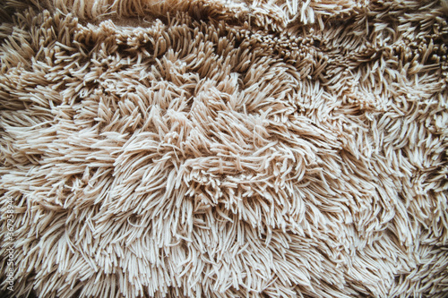 Background of beige fur. Long wool. The texture of the fur. Fur covering.