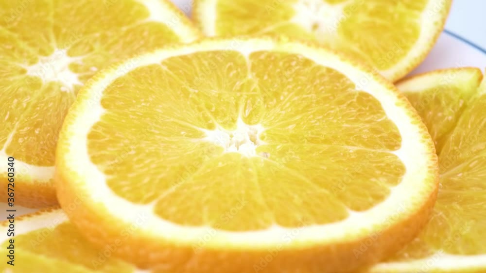 Close up fresh valencia orange sliced with white background shallow focus and slowly rotating. Close up fresh valencia orange sliced with white background shallow focus and slowly rotating.