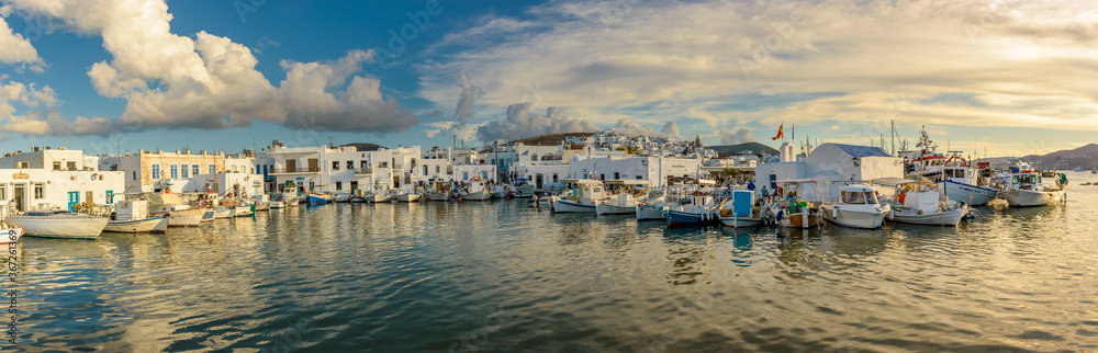 Panorama view of the picturesque port in Naousa village with tradittional boats and whitewashed houses  on Paros island, Greece. Taken on a beautifull afternoon with calm sea and amazing clouds
