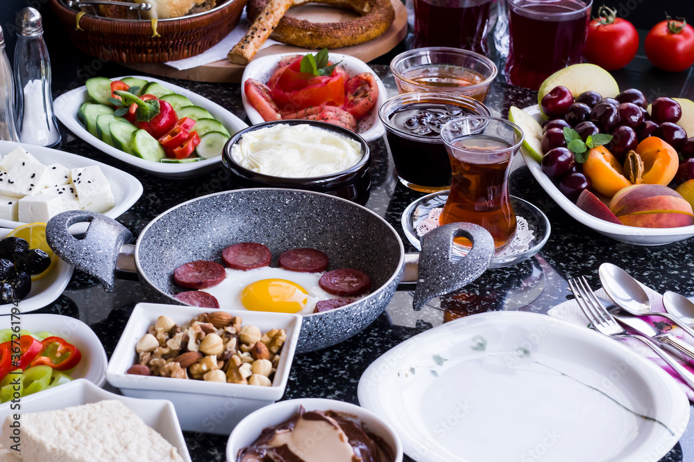 Traditional Turkish Breakfast with sausage egg pan on granite marble table.Close and large view Traditional Turkish Breakfast with sausage egg pan on granite marble table.Close and large view