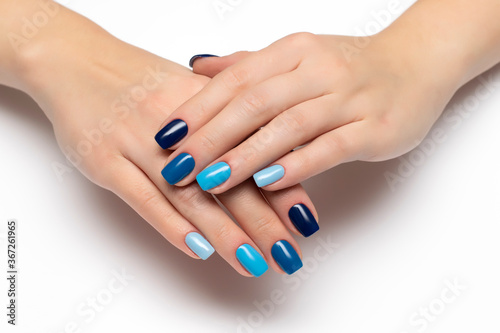 Gel nail design. Multi-colored blue manicure from dark to light on long square nails.