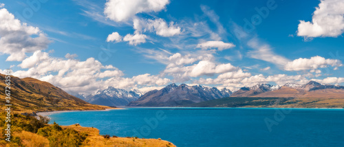 Breathtaking alpine scenery with snow-capped mountains in the distance  at Lake Pukaki  a glacial lake in Mount Cook NP in New Zealand s South Island  one of the iconic touristic destinations.