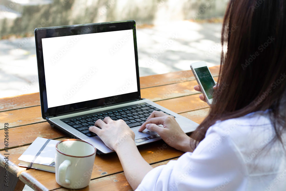 Fototapeta premium Business concept : Back view of business woman hands busy using laptop at cafe, Young woman working on his laptop with blank copy space screen for your advertising text message in cafe.