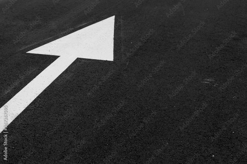 white arrow on asphalt to define direction white arrow on asphalt to define direction
