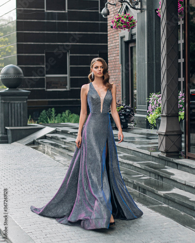 Billede på lærred Beautiful young fashion gorgeous woman walks, modern black building, granite steps