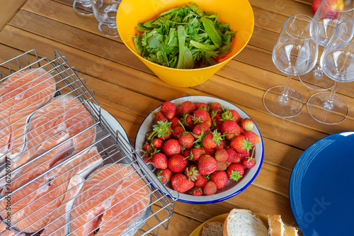 picnic in nature. salmon steaks, berries, wine glasses, bread basket. Bright dishes