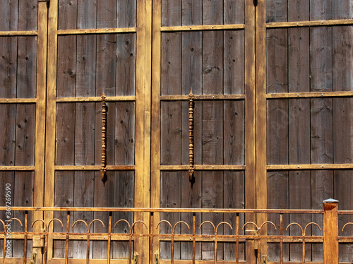 large wooden courtyard door and metal fence