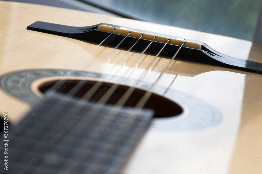 Obraz premium Acoustic guitar of yellow-brown color, close-up, top view
