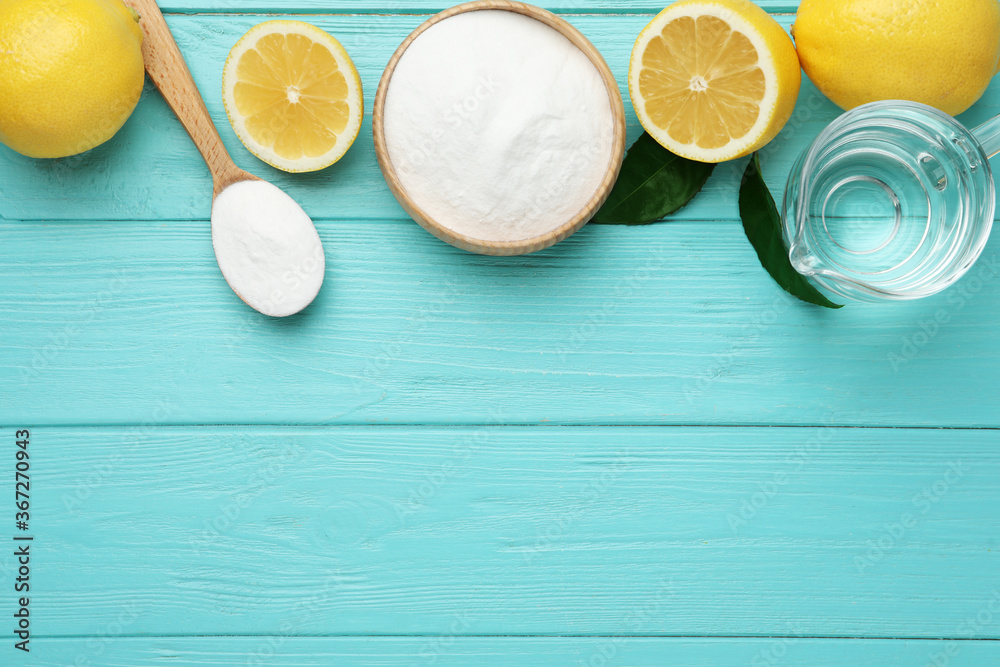 Baking soda, vinegar and cut lemons on light blue wooden table, flat lay. Space for text Baking soda, vinegar and cut lemons on light blue wooden table, flat lay. Space for text