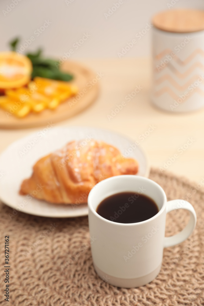 Cup of hot aromatic coffee and tasty croissant on table Cup of hot aromatic coffee and tasty croissant on table