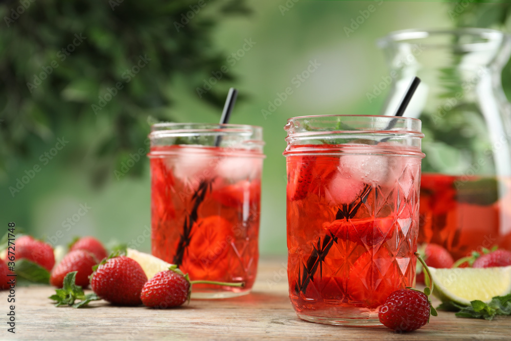 Refreshing drink with strawberry and lime on wooden table - obrazy, fototapety, plakaty 
