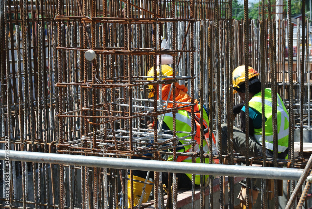 MALACCA, MALAYSIA -MAY 16, 2016: Construction workers fabricating steel reinforcement bar at the construction site in Malacca, Malaysia. The reinforcement bar was tied together using tiny wire.  
