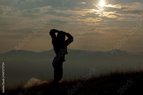 silhouette of a girl on a background of clouds sky in the mountains