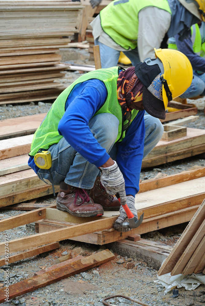 Johor, Malaysia -June 01, 2016: Carpenter working at the construction site during the daytime. Johor, Malaysia -June 01, 2016: Carpenter working at the construction site during the daytime.