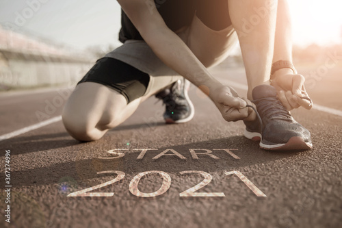 2021 symbolises the start into the new year.Start of people running on street,with sunset light.Goal of Success photo