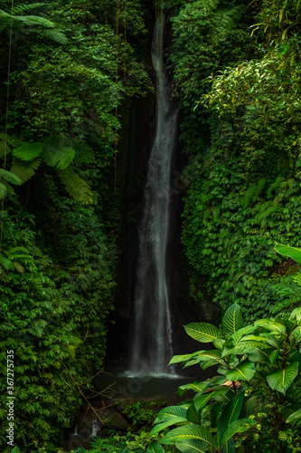 Waterfall landscape. Beautiful hidden Leke Leke waterfall in Bali. Waterfall in tropical rainforest. Slow shutter speed  motion photography.