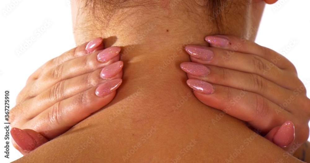 Woman back view while she is massaging her neck. Neck pain concept.