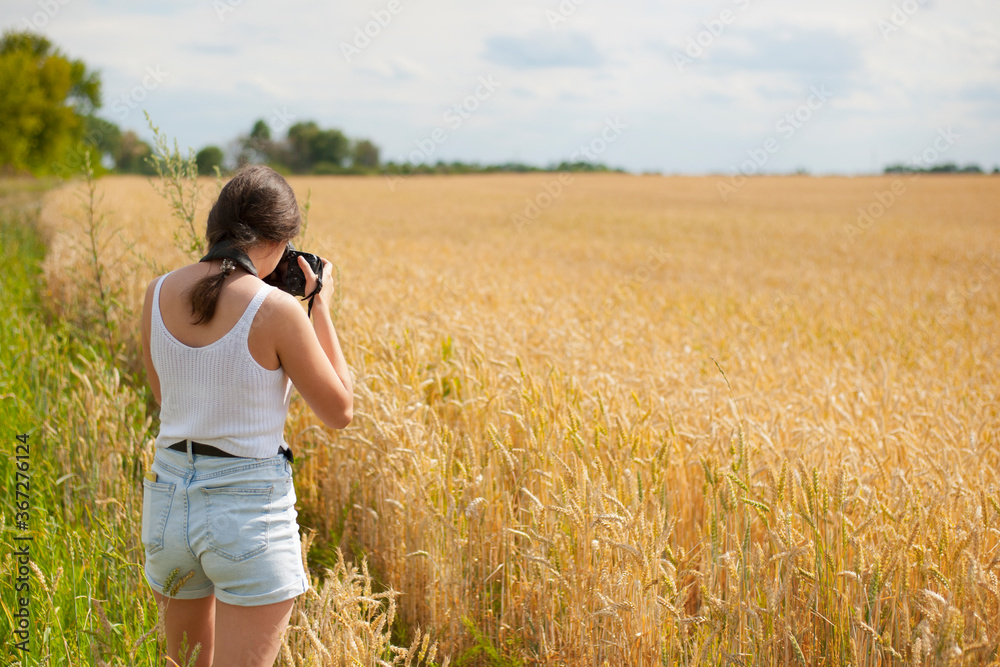 girl photographer with camera in a wheat field back view
girl photographer with camera in a wheat field back view