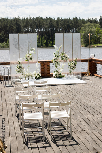 Wedding ceremony with white transparent screens and fresh white flowers and candles