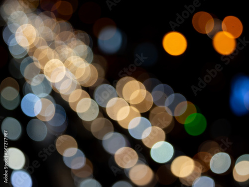 Abstract bokeh night light background, blurred lights traces from cars on road, defocused city traffic on street at night