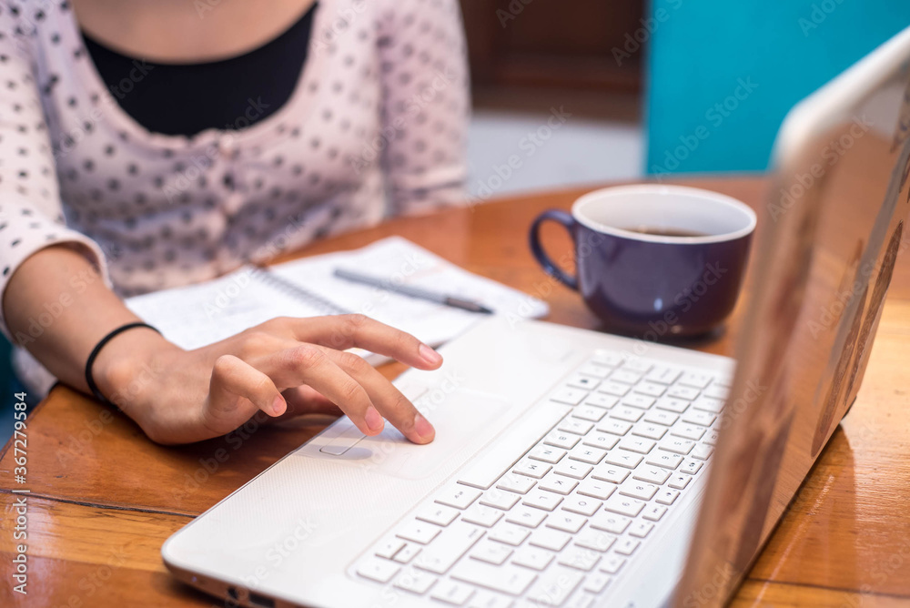 woman working on laptop a notebook and a cup of coffee woman working on laptop a notebook and a cup of coffee