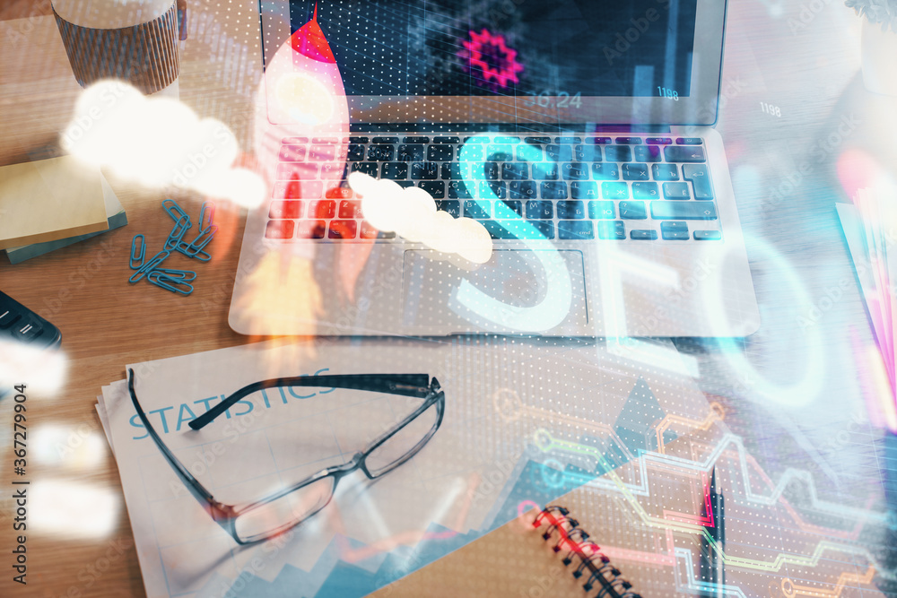 © peshkova - Double exposure of table with computer and seo drawing hologram. Search optimization concept.