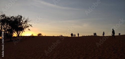 the desert of Vietnam. silhouette of sand mountains and sunset people