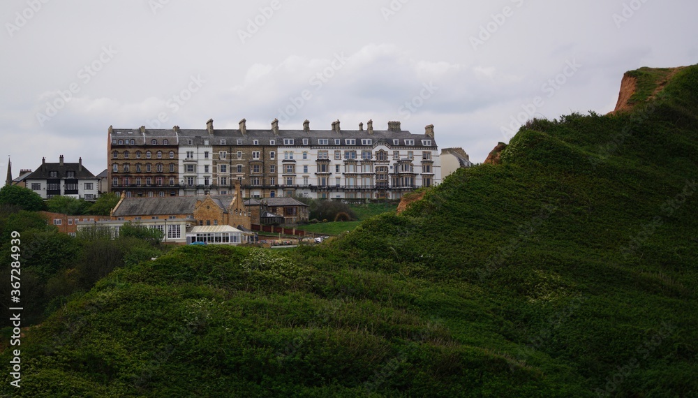 Landscape showing grassy hills and a row of terrace houses in Saltburn-by-the-Sea, Yorkshire, England