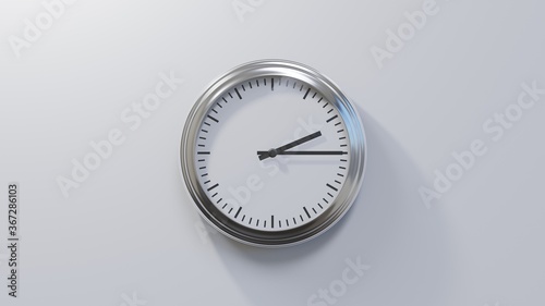 Glossy chrome clock on a white wall at quarter past two. Time is 02:15 or 14:15