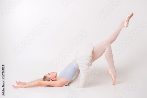 beautiful young blonde woman ballerina training calilisthenics exercise on white studio background.