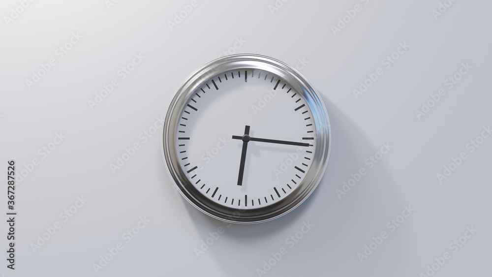 Glossy chrome clock on a white wall at sixteen past six. Time is 06:16 or 18:16 Glossy chrome clock on a white wall at sixteen past six. Time is 06:16 or 18:16