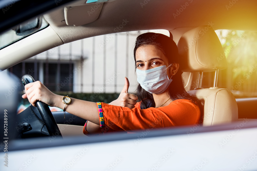 Indian young woman or girl wearing face mask while driving car Stock Photo  | Adobe Stock
