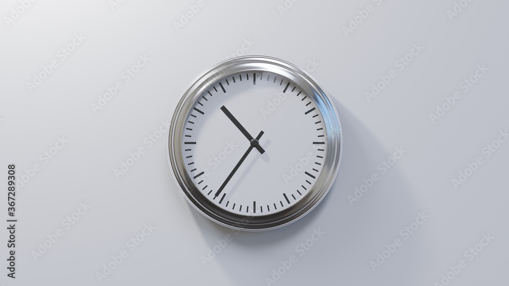 Glossy chrome clock on a white wall at thirty-six past ten. Time is 10:36 or 22:36 Glossy chrome clock on a white wall at thirty-six past ten. Time is 10:36 or 22:36
