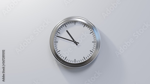 Glossy chrome clock on a white wall at forty-eight past ten. Time is 10:48 or 22:48 photo