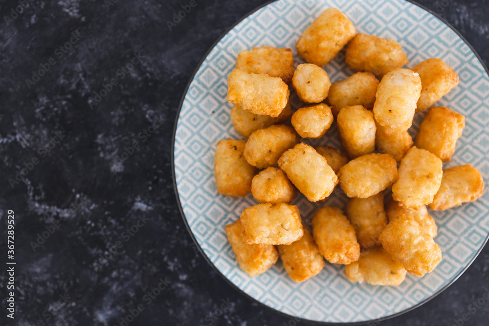 simple food ingredients, air fryed potato royals on small snack plate on dark background simple food ingredients, air fryed potato royals on small snack plate on dark background