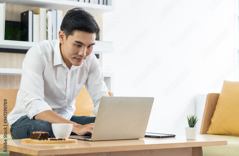 young handsome asian man using computer to work from home. business and technology concept