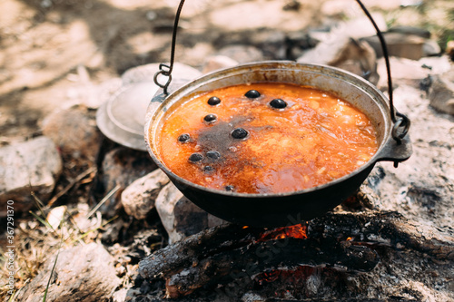 Cooking outdoors. Solyanka, meat hodgepodge soup in a large pot