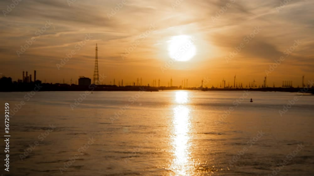 Antwerp International Port, dramatic timelapse at sunset with cargo ships passing. Antwerp International Port, dramatic timelapse at sunset with cargo ships passing.