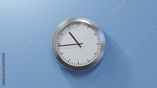 Glossy chrome clock on a blue wall at forty-four past ten. Time is 10:44 or 22:44