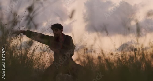 Man doing kungfu  among the vegetation. Cinematic video photo