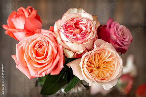 Beautiful roses in a vase on a wooden background