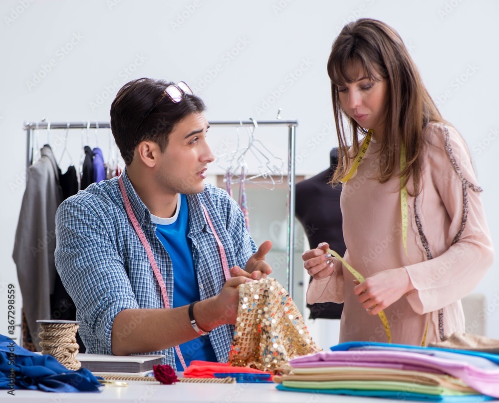 Fototapeta premium Male tailor with female student in workshop