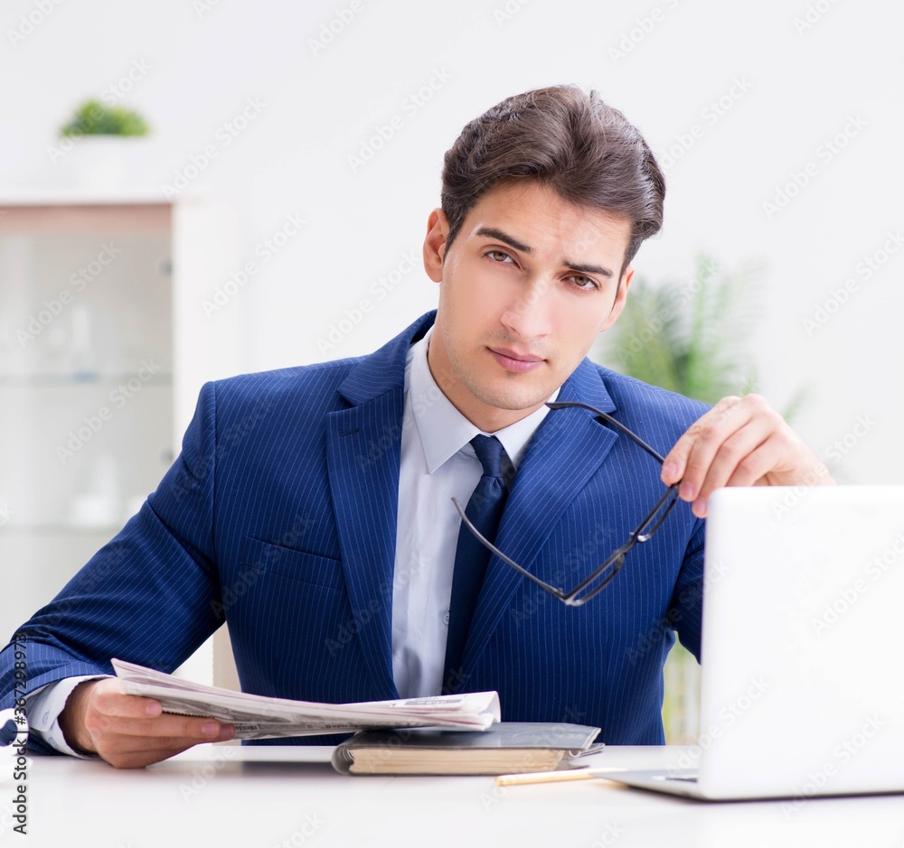 Young handsome businessman employee working in office at desk Young handsome businessman employee working in office at desk