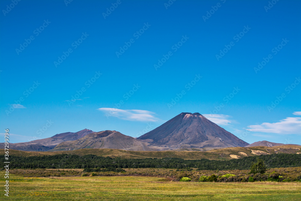 Volcanic cone of Mount Ngauruhoe rising over valley on a fine summer day Volcanic cone of Mount Ngauruhoe rising over valley on a fine summer day