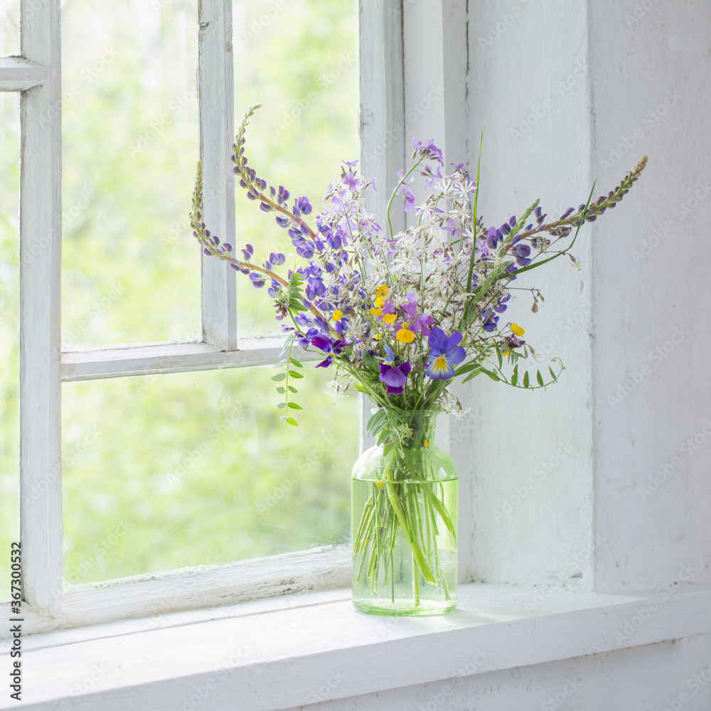 wild flowers in vase on white windowsill wild flowers in vase on white windowsill
