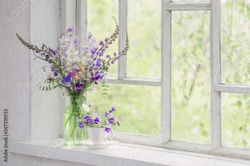 wild flowers in vase on white windowsill