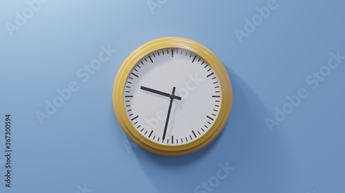 Glossy orange clock on a blue wall at thirty-two past nine. Time is 09:32 or 21:32