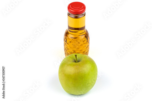 Apple juice bottle. Nearby are juicy, beautiful apples.