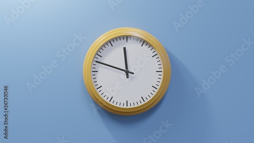 Glossy orange clock on a blue wall at forty-eight past eleven. Time is 11:48 or 23:48 photo