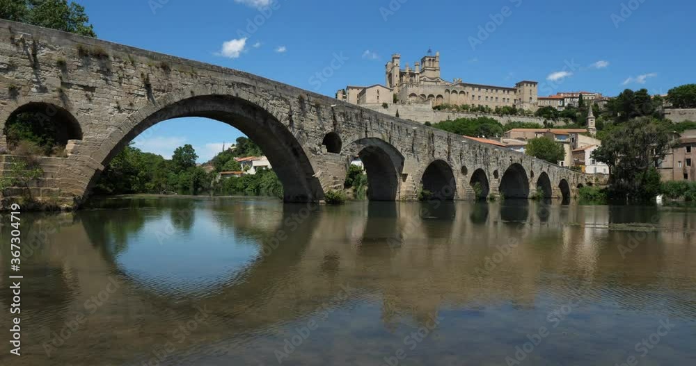 Beziers, Herault, Occitanie, France. In the foreground, the old bridge over crossing the Orb river. In the background is the cathedral Saint Nazaire Beziers, Herault, Occitanie, France. In the foreground, the old bridge over crossing the Orb river. In the background is the cathedral Saint Nazaire